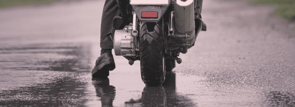 A motorbike parked near the wet road