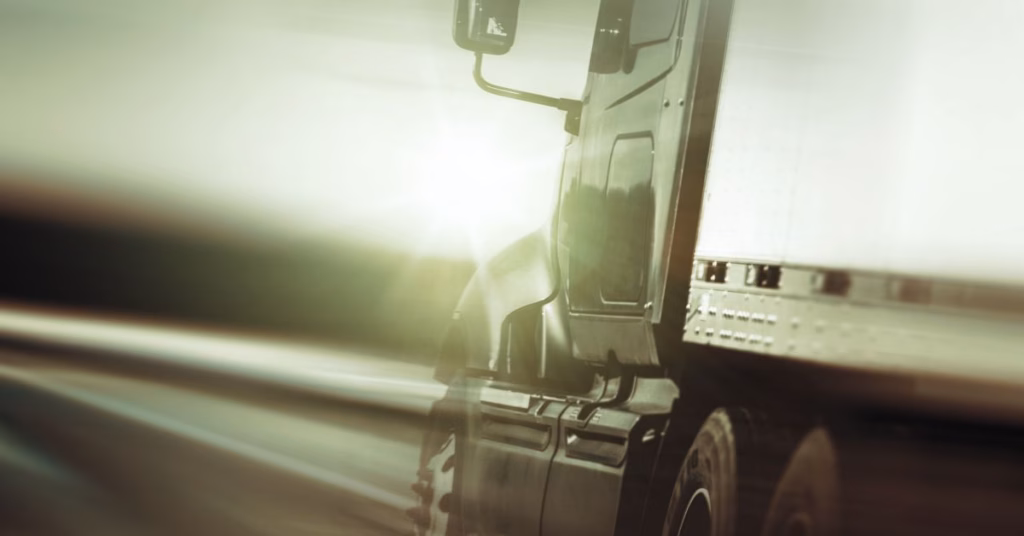 Semi-truck driving on highway at sunset, highlighting concerns about negligent hiring and FMCSA safety rule changes in Kansas City.