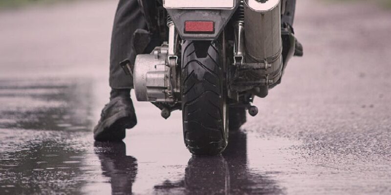 A motorbike parked near the wet road